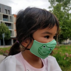 Cara niña con mascarilla infantil de tela reutilizable homologada ffp2. Dibujo rana verde